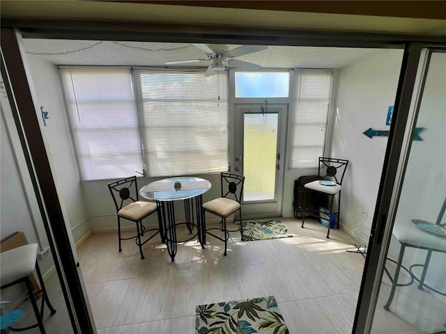 sunroom / solarium featuring a healthy amount of sunlight and ceiling fan