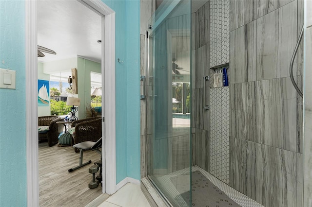 bathroom with hardwood / wood-style flooring and tiled shower