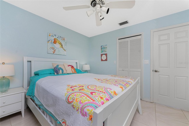 bedroom with a closet, light tile patterned floors, and ceiling fan