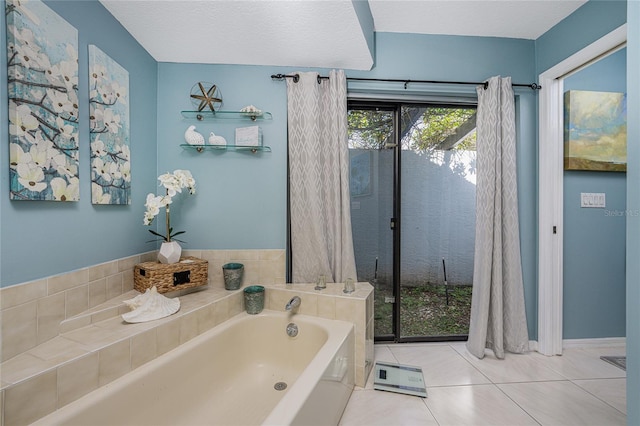 bathroom featuring a textured ceiling, a tub to relax in, and tile patterned flooring