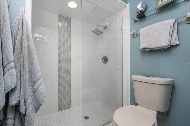 bathroom featuring a tile shower and toilet