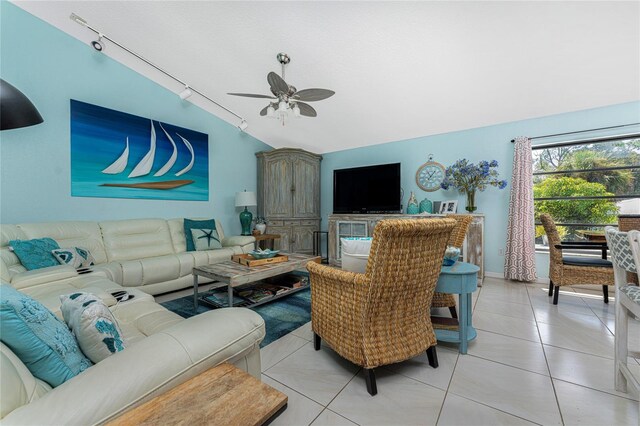 tiled living room with lofted ceiling, rail lighting, and ceiling fan