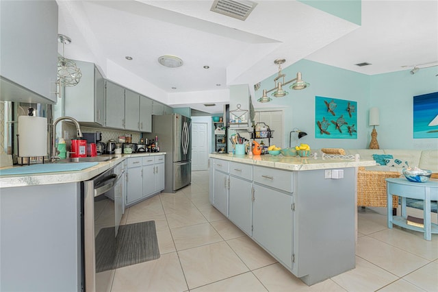 kitchen featuring backsplash, appliances with stainless steel finishes, light tile patterned floors, gray cabinets, and sink