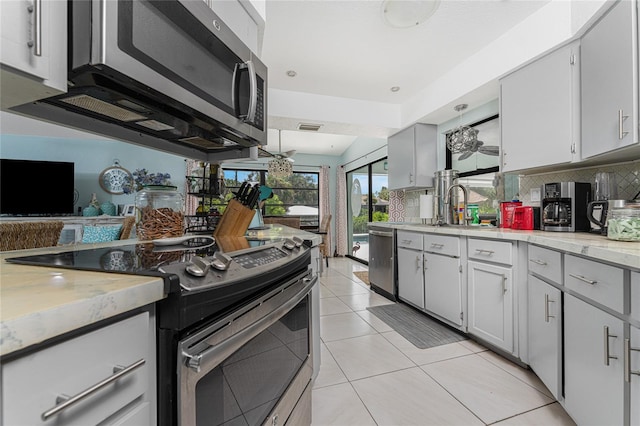 kitchen featuring sink, light tile patterned flooring, decorative backsplash, and stainless steel appliances