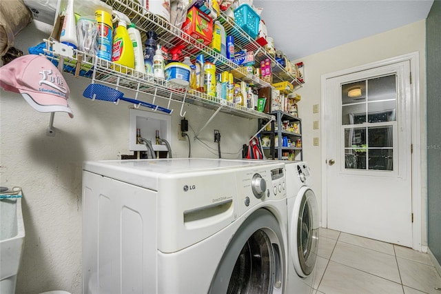 clothes washing area featuring light tile patterned flooring and washer and clothes dryer