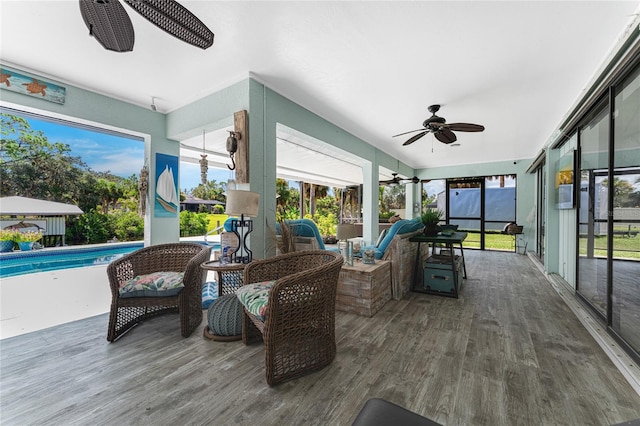 sunroom featuring a swimming pool and ceiling fan