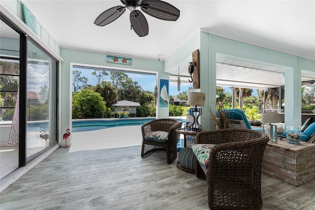 sunroom / solarium featuring ceiling fan and a swimming pool