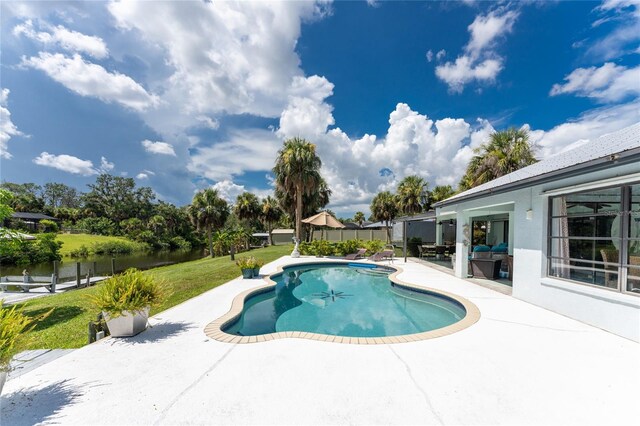 view of swimming pool with a patio and a water view