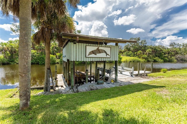 view of dock with a water view and a lawn