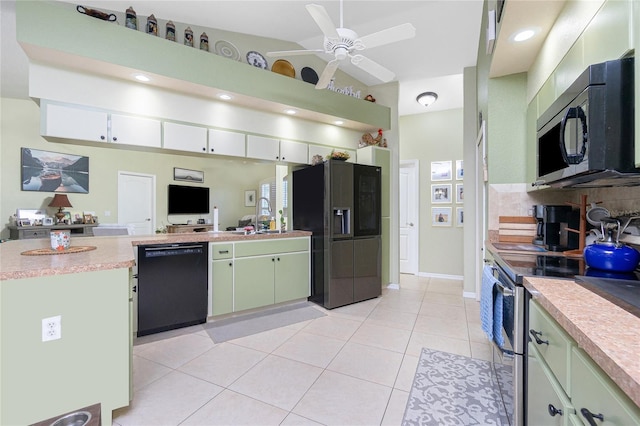 kitchen featuring black appliances, light tile patterned floors, green cabinetry, sink, and decorative backsplash