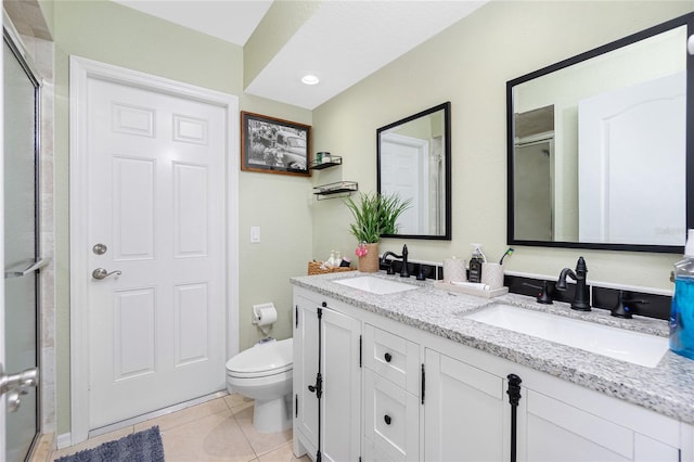 bathroom featuring toilet, vanity, tile patterned floors, and a shower with door