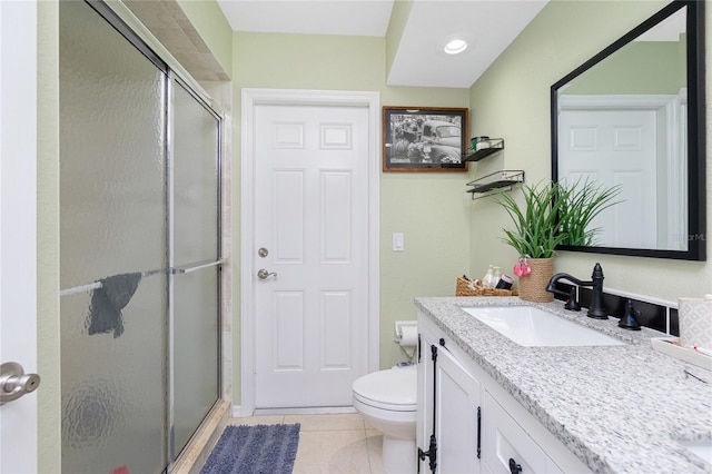 bathroom with vanity, a shower with shower door, tile patterned flooring, and toilet