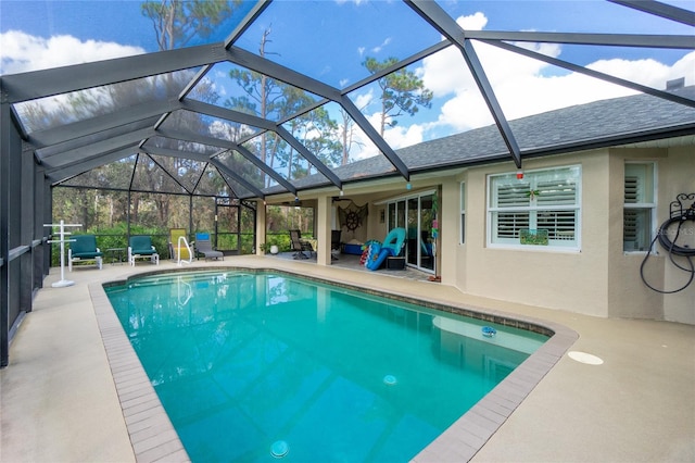 view of swimming pool with glass enclosure and a patio area