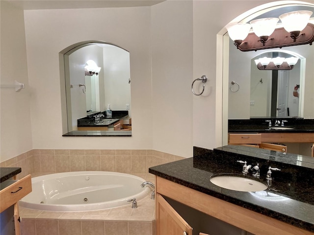 bathroom with vanity and tiled tub