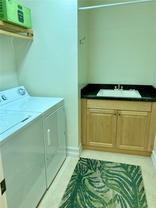 washroom featuring cabinets, washer and clothes dryer, sink, and light tile patterned floors