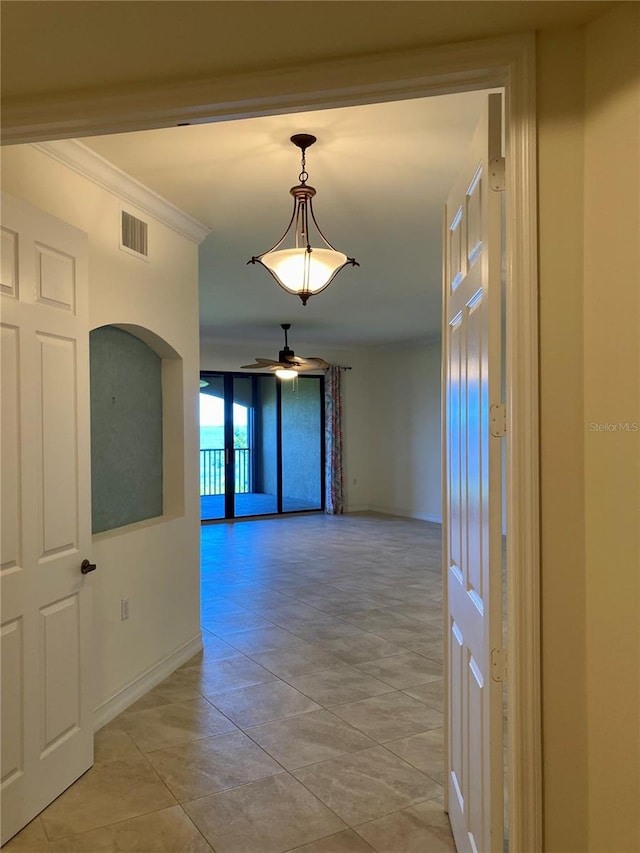 hall featuring light tile patterned floors and crown molding