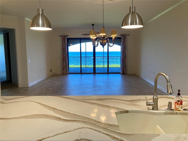 kitchen featuring pendant lighting, a water view, ceiling fan, and crown molding