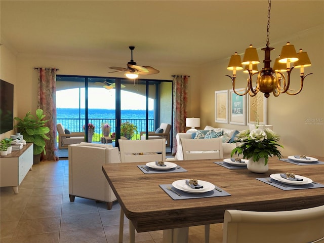 tiled dining area featuring a water view and ceiling fan with notable chandelier