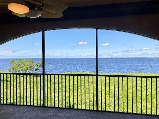 unfurnished sunroom with a water view and ceiling fan