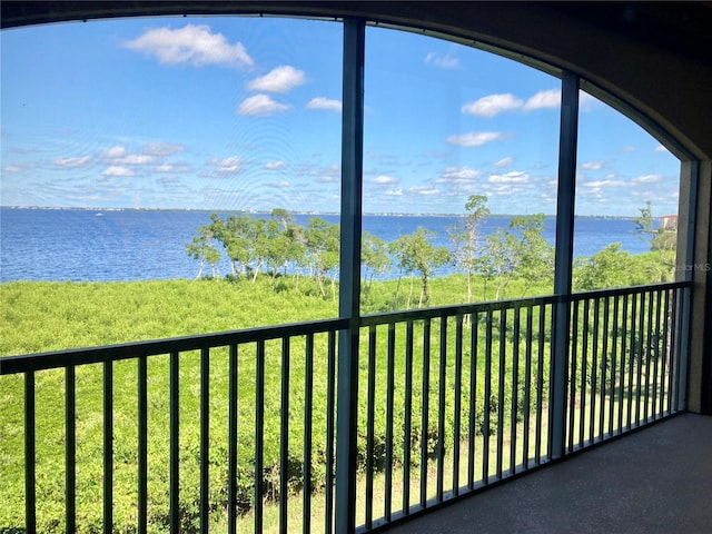 unfurnished sunroom featuring a water view