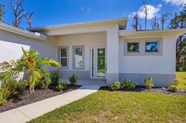 entrance to property featuring a lawn