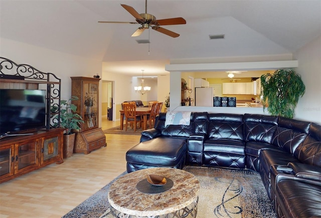 living room featuring vaulted ceiling, ceiling fan with notable chandelier, and light wood-type flooring