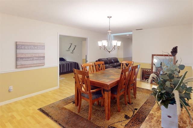 dining area featuring hardwood / wood-style flooring and a chandelier