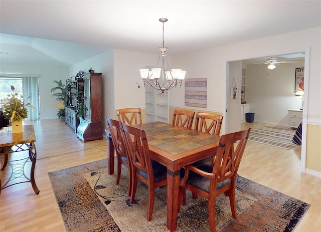 dining space featuring ceiling fan with notable chandelier and light wood-type flooring