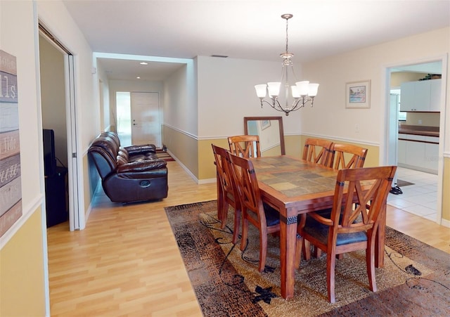 dining room featuring an inviting chandelier and light wood-type flooring