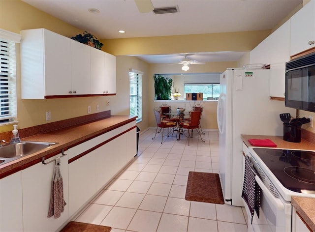 kitchen with white cabinetry, ceiling fan, light tile patterned floors, and white range