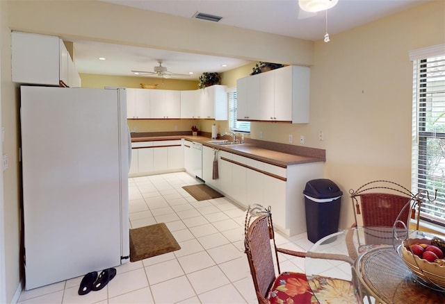 kitchen with a wealth of natural light, white cabinets, and white appliances