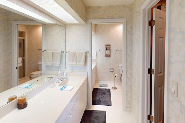 bathroom with toilet, vanity, and tile patterned floors