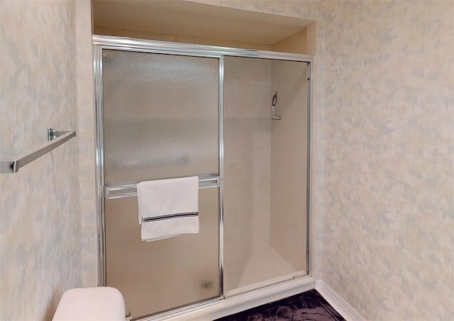 bathroom with toilet and a shower with shower door