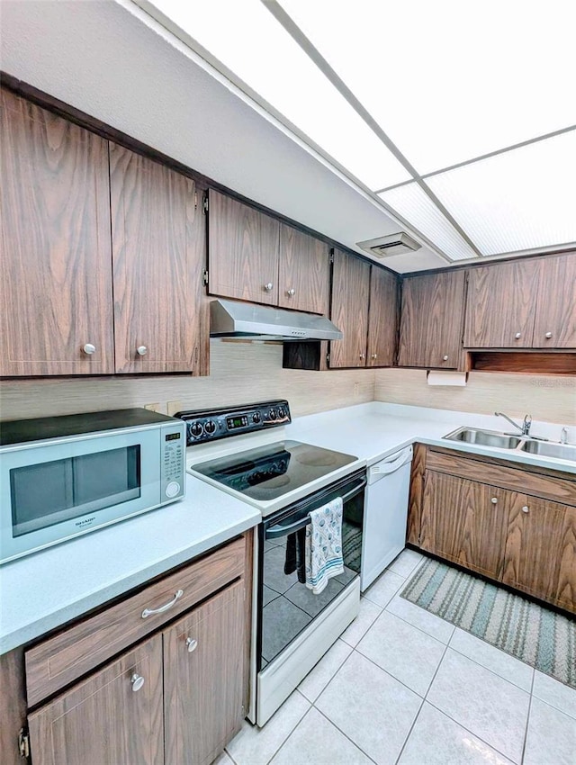 kitchen with sink, white appliances, and light tile patterned floors