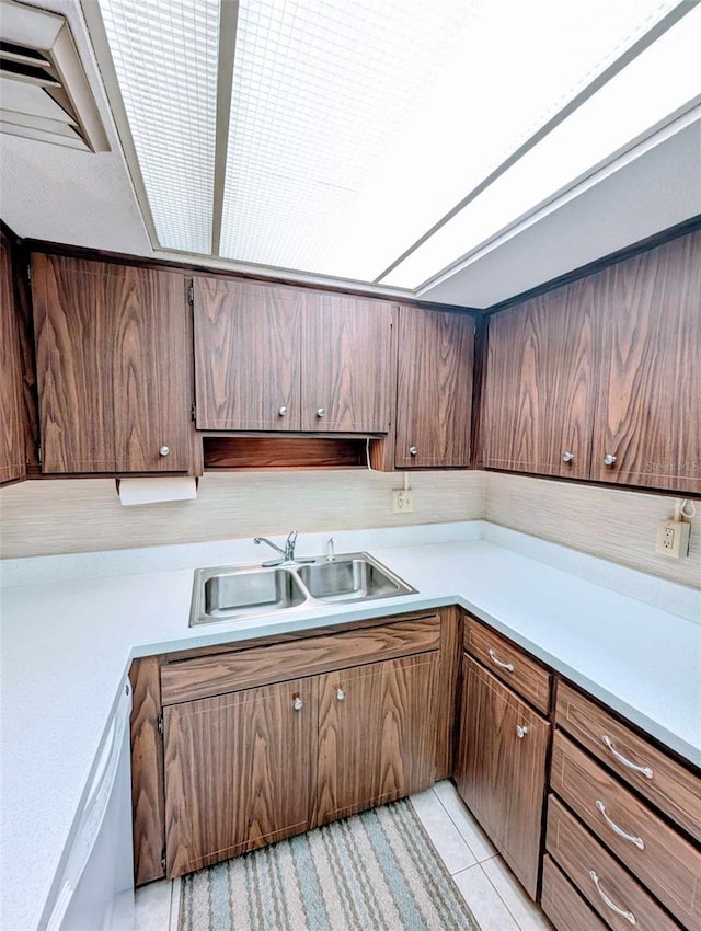 kitchen featuring sink, light tile patterned flooring, and dishwasher