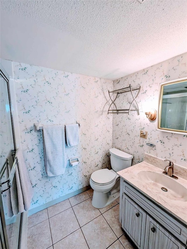 bathroom with vanity, a textured ceiling, toilet, and tile patterned floors