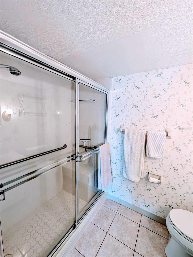 bathroom featuring toilet, a textured ceiling, tile patterned flooring, and an enclosed shower