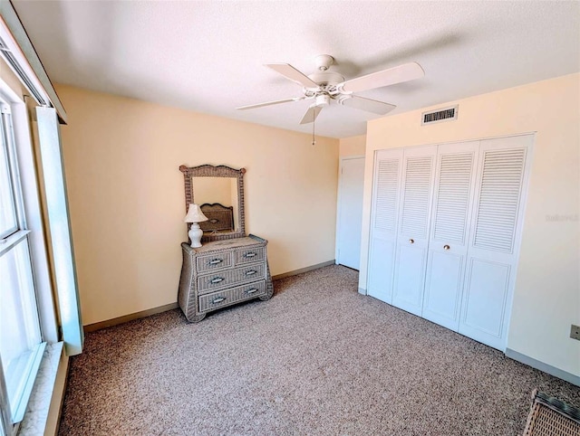 bedroom featuring a closet, ceiling fan, carpet flooring, and a textured ceiling