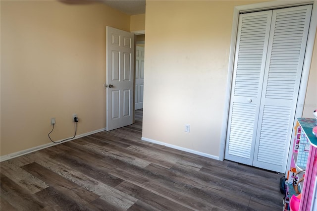 unfurnished bedroom with dark hardwood / wood-style floors and a closet