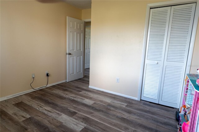 860 Columbia St, Port Charlotte, FL 33948 - unfurnished bedroom featuring a closet, dark wood finished floors, and baseboards