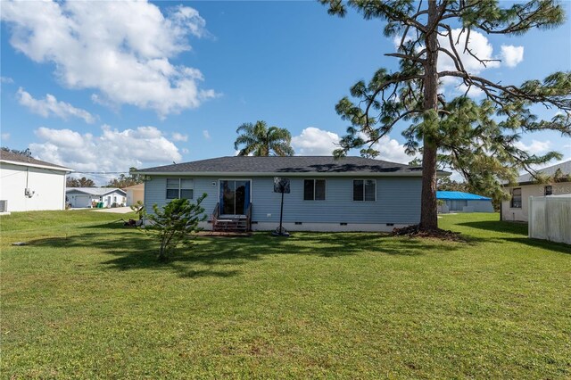 860 Columbia St, Port Charlotte, FL 33948 - back of house featuring crawl space, a lawn, and entry steps