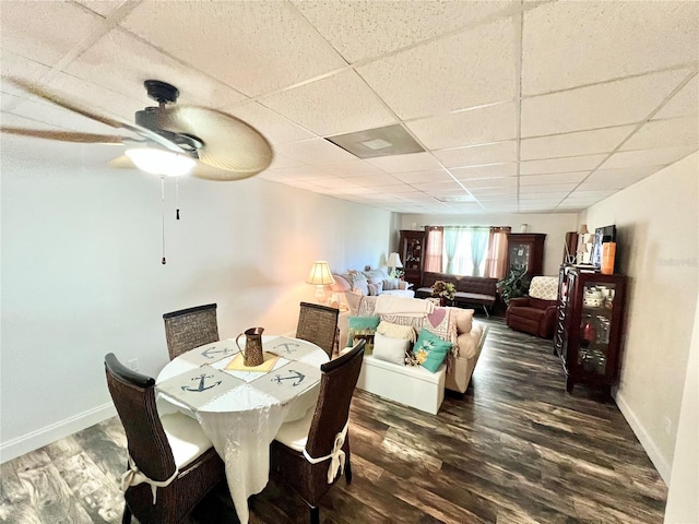 dining area featuring ceiling fan, a paneled ceiling, and dark hardwood / wood-style flooring