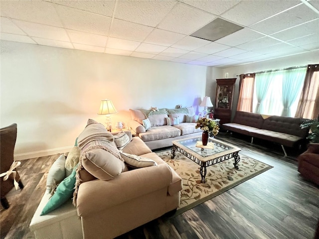 living room with dark wood-type flooring and a drop ceiling