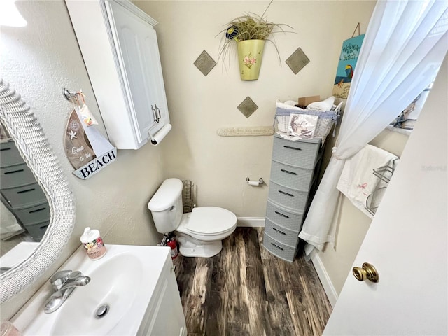 bathroom with vanity, hardwood / wood-style flooring, and toilet