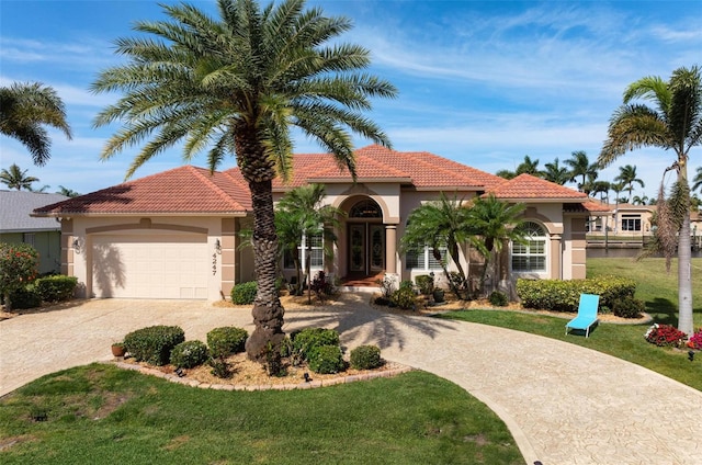 mediterranean / spanish-style house featuring a front lawn and a garage