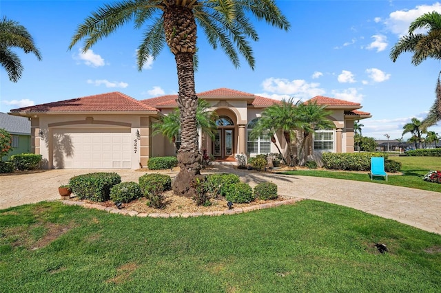 mediterranean / spanish house featuring a garage and a front lawn