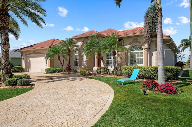 mediterranean / spanish home featuring a garage and a front lawn