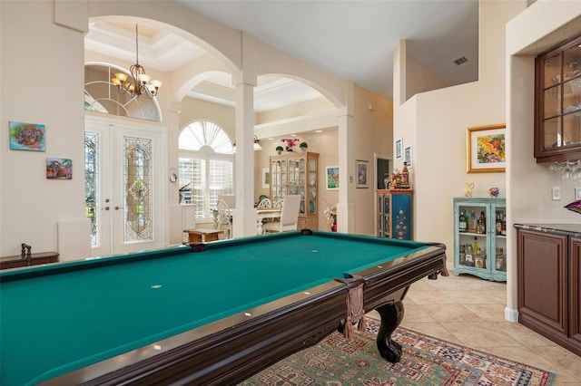 recreation room with french doors, pool table, light tile patterned flooring, an inviting chandelier, and a towering ceiling