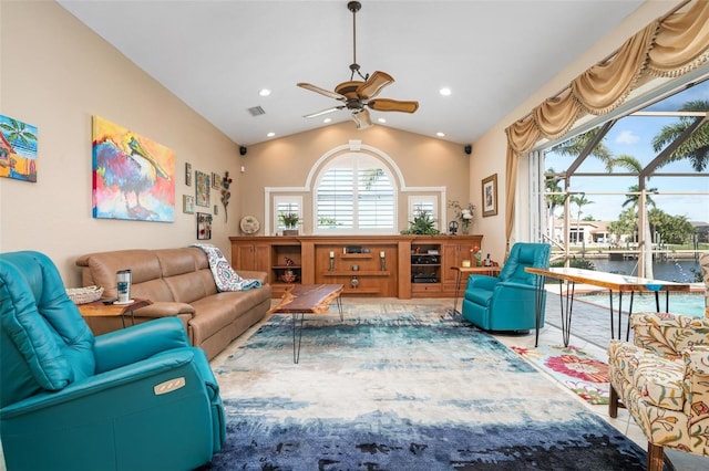 living room featuring ceiling fan, a water view, and vaulted ceiling