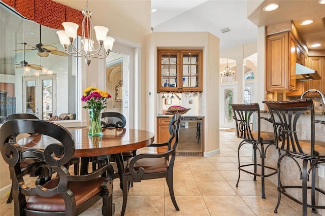 dining area with light tile patterned floors and ceiling fan with notable chandelier